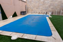 Small,Pool,Covered,With,A,Blue,Tarpaulin,During,The,Winter